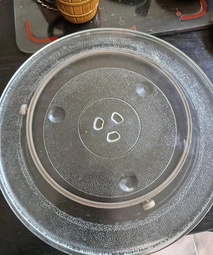 Dont throw out the turntable from your old microwave! It makes a great Lazy Susan for cupboards or the dining table. Place it under an oil lantern as a heat barrier and to catch any leaks or spills. Theres even enough space to add a Christmas wreath around the lantern, creating a beautiful winter centerpiece!